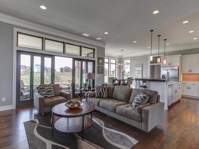 living room with dark wood-style flooring, ornamental molding, a healthy amount of sunlight, and recessed lighting