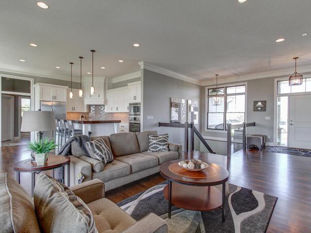 living room with dark wood-type flooring, baseboards, recessed lighting, and crown molding