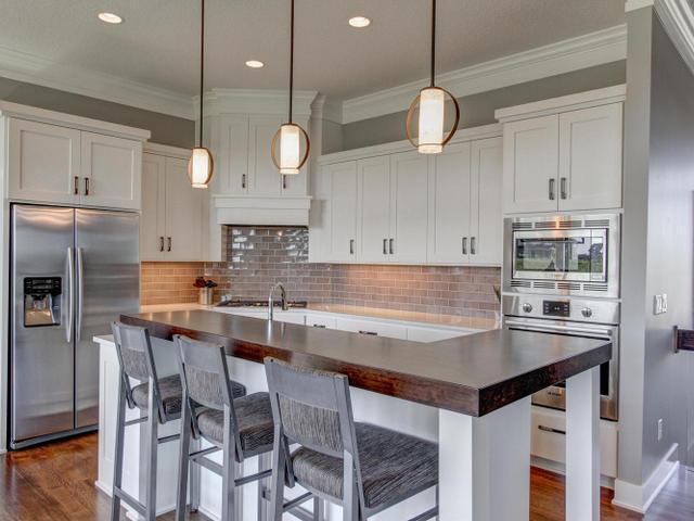 kitchen featuring dark wood-style floors, white cabinets, ornamental molding, and stainless steel appliances