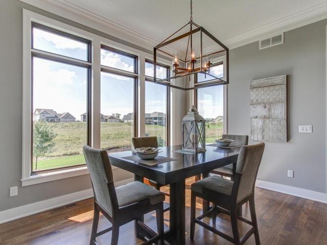 dining room with ornamental molding, dark wood-style floors, a chandelier, and visible vents