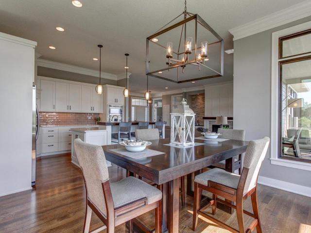 dining room featuring crown molding, dark wood finished floors, baseboards, recessed lighting, and an inviting chandelier