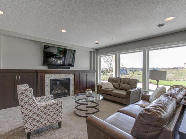 carpeted living room with recessed lighting, a fireplace, and a textured ceiling