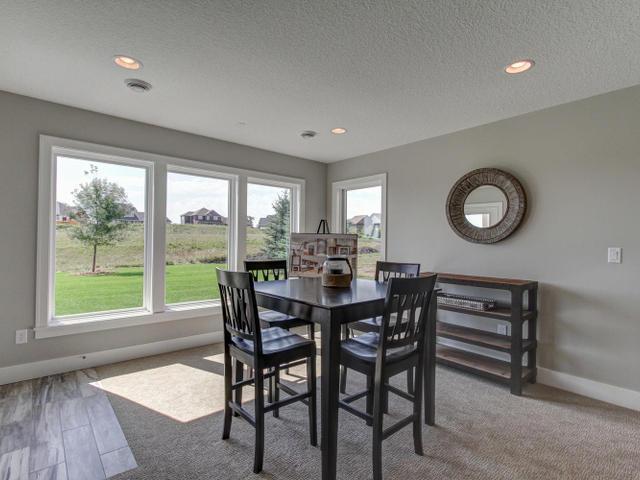 dining room featuring baseboards, wood finished floors, recessed lighting, and a textured ceiling