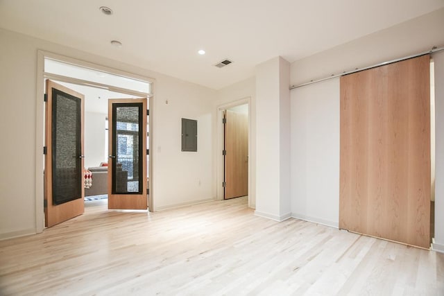 unfurnished bedroom with electric panel, a closet, and light wood-type flooring