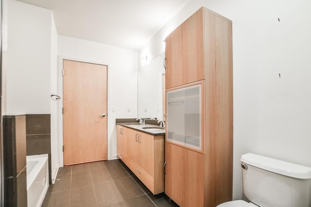 bathroom featuring vanity, toilet, and a tub