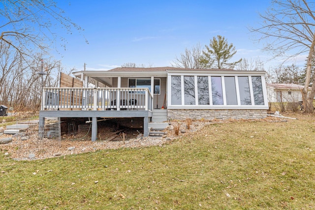 back of property featuring a sunroom, a yard, and a deck