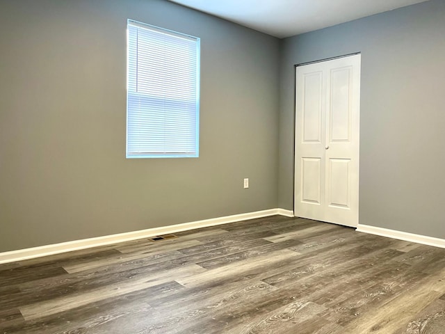 unfurnished bedroom with dark wood-type flooring