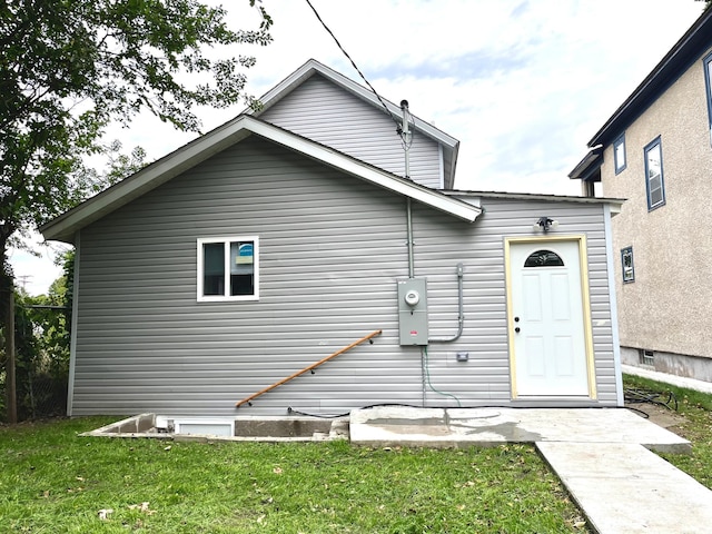 rear view of property featuring a yard