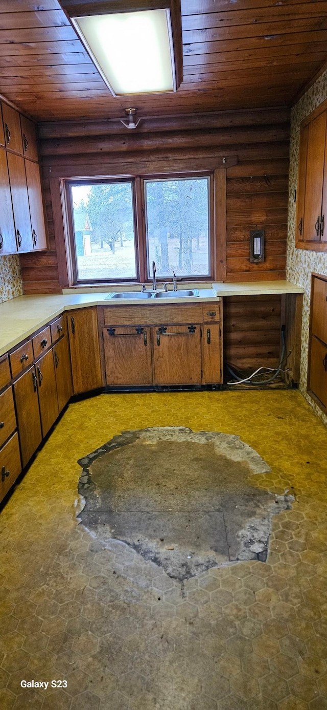 kitchen featuring sink, wood walls, and wood ceiling