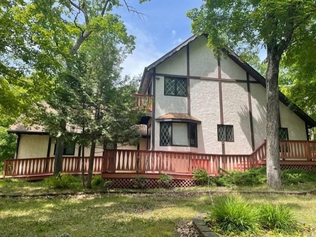 33820 County Highway 34, Sugar Bush E Twp, MN 56569 - back of house featuring stucco siding, a deck, and a lawn