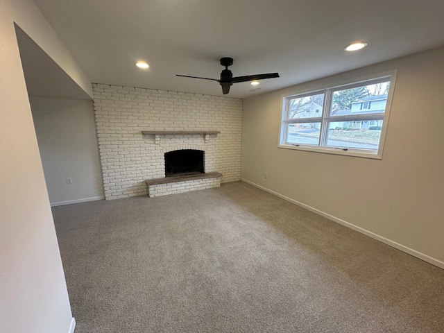 unfurnished living room with ceiling fan, carpet floors, and a brick fireplace