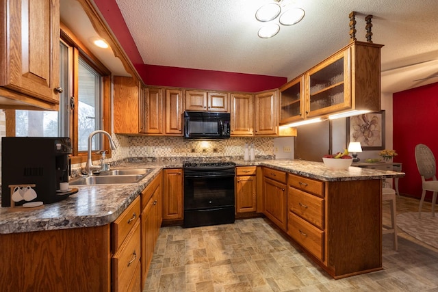 kitchen with kitchen peninsula, a textured ceiling, sink, and black appliances