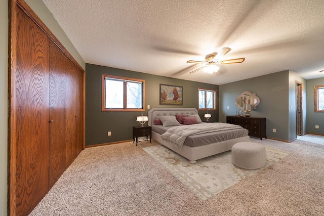 carpeted bedroom with multiple windows, ceiling fan, and a textured ceiling