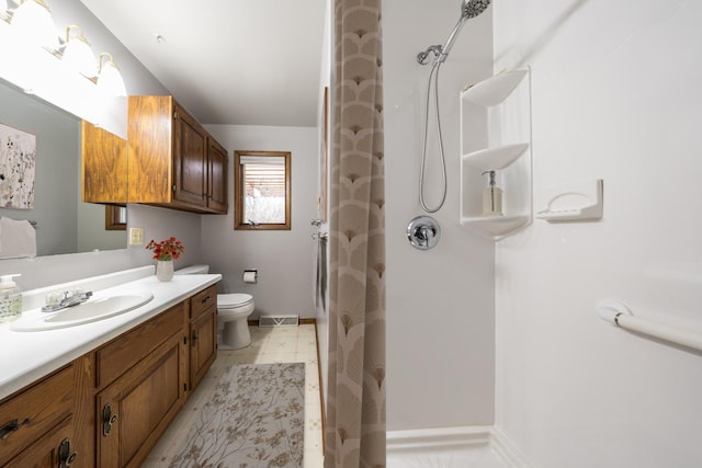 bathroom with tile patterned floors, toilet, vanity, and walk in shower