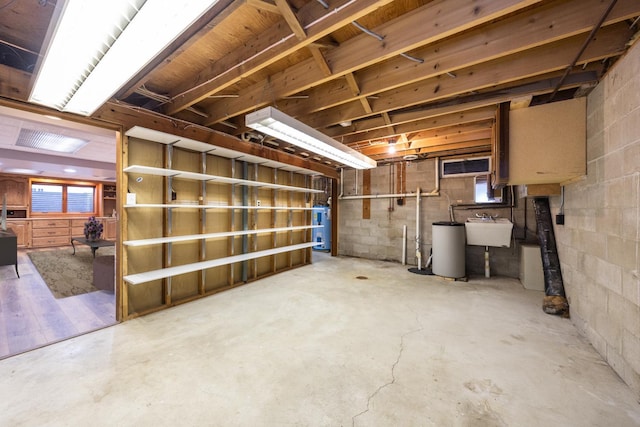 basement featuring electric water heater and sink