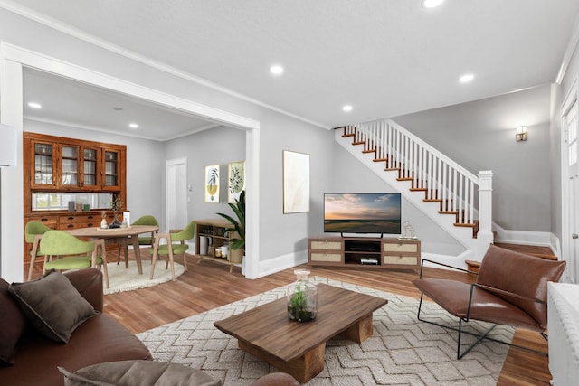 living room featuring a wealth of natural light, crown molding, and light wood-type flooring