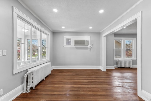 spare room with a textured ceiling, dark hardwood / wood-style floors, and radiator