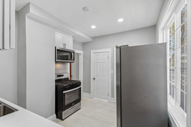 kitchen featuring white cabinetry, backsplash, and appliances with stainless steel finishes