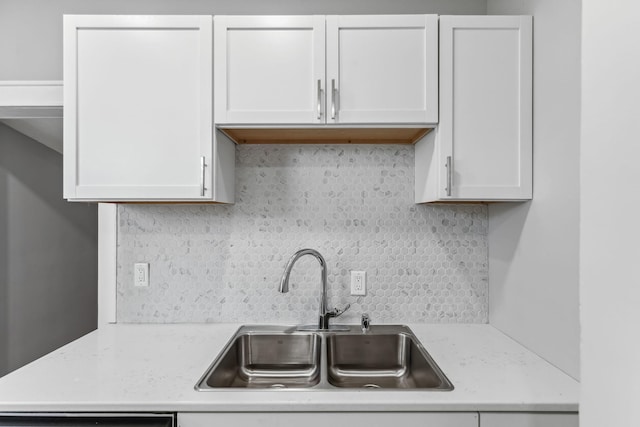 kitchen with dishwasher, sink, tasteful backsplash, light stone counters, and white cabinetry