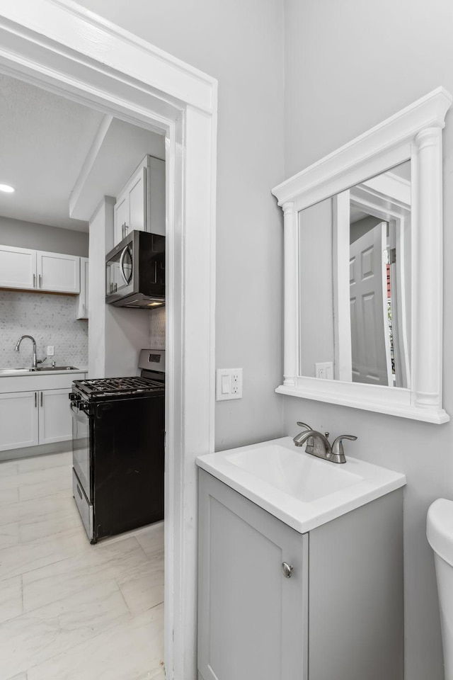 bathroom with vanity, toilet, and tasteful backsplash