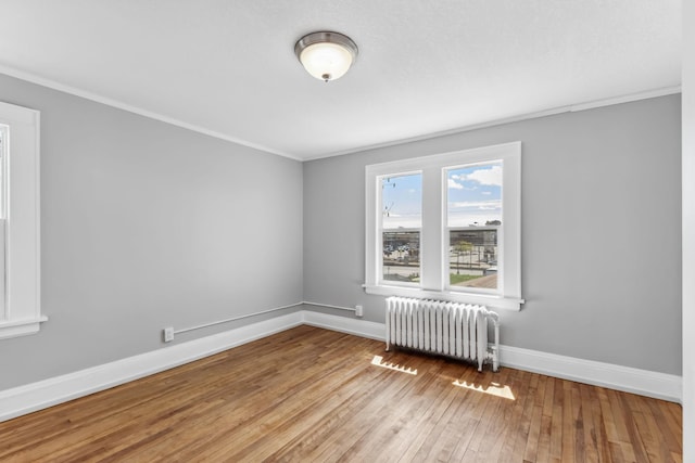 unfurnished room featuring radiator, crown molding, and light hardwood / wood-style flooring