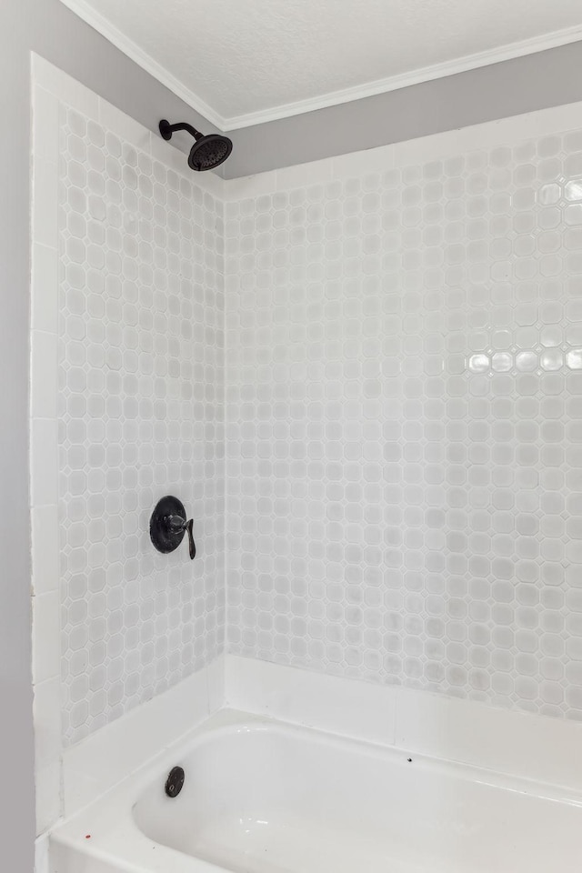 bathroom featuring tub / shower combination, a textured ceiling, and crown molding