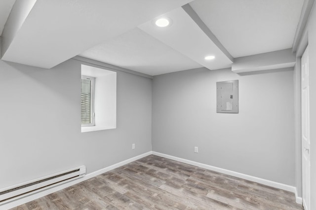 basement with baseboard heating, electric panel, and wood-type flooring