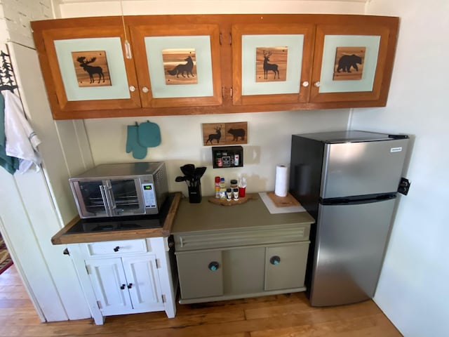 kitchen with stainless steel fridge and light wood-type flooring