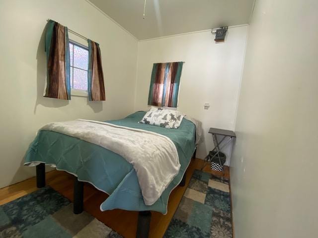 bedroom featuring ornamental molding and hardwood / wood-style flooring