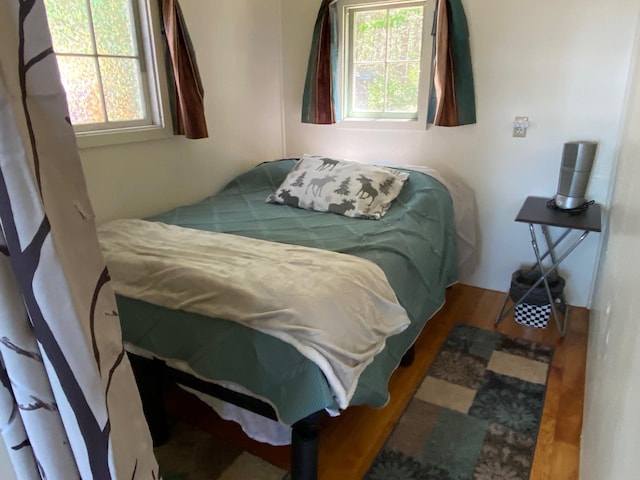 bedroom with hardwood / wood-style floors and multiple windows