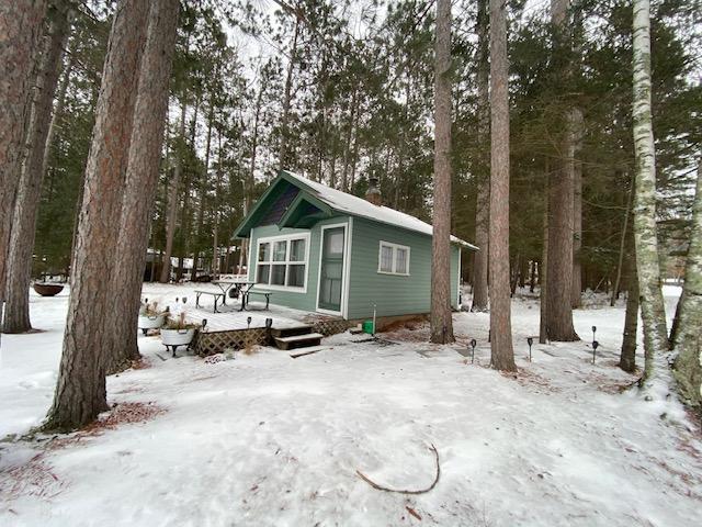 snow covered house featuring a wooden deck