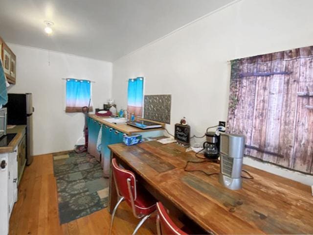 kitchen featuring black refrigerator and light hardwood / wood-style flooring