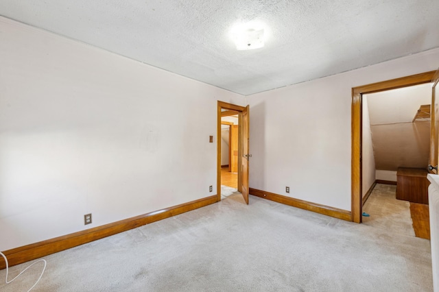 spare room with a textured ceiling and light carpet