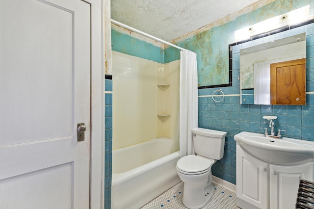 full bathroom featuring shower / bath combination with curtain, vanity, a textured ceiling, tile patterned flooring, and toilet