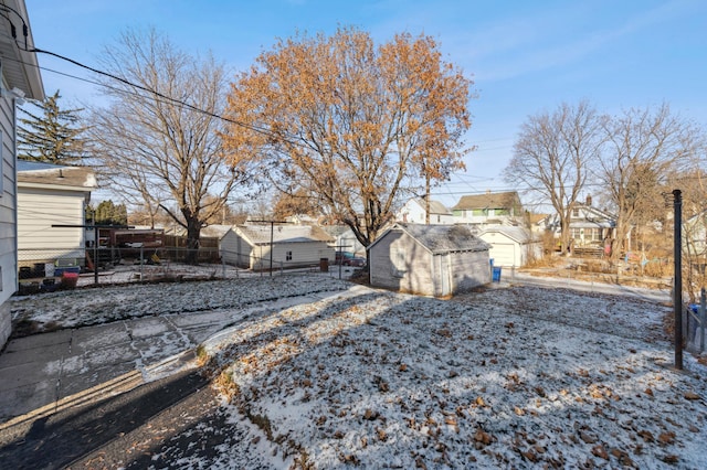 yard layered in snow featuring a storage shed