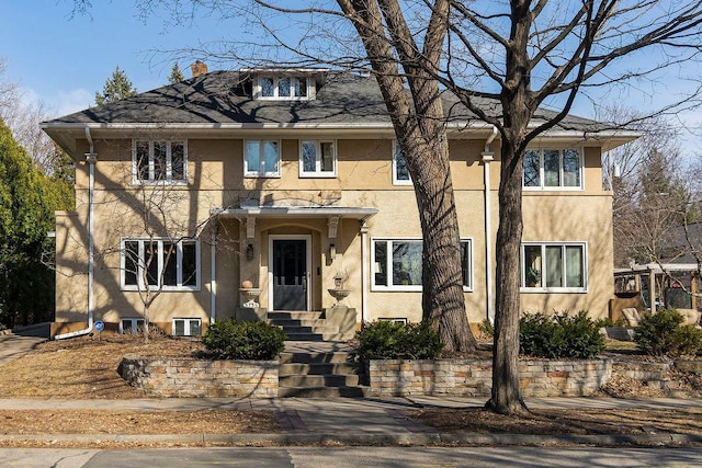 view of front of house with a chimney and stucco siding