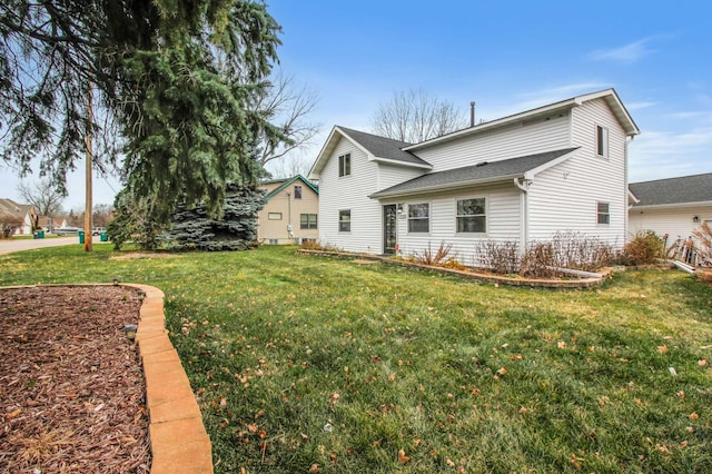 rear view of property featuring a lawn