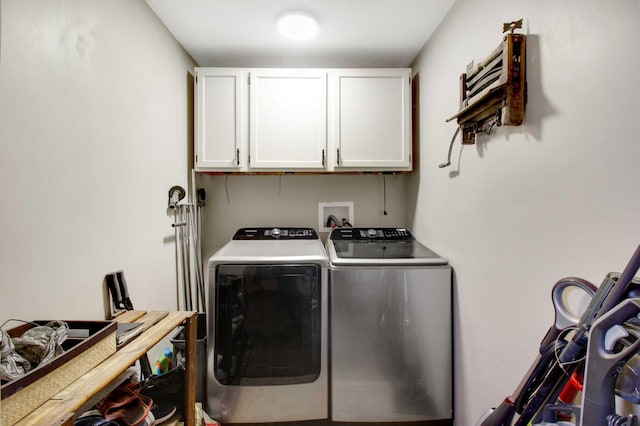 clothes washing area with cabinets and washing machine and dryer