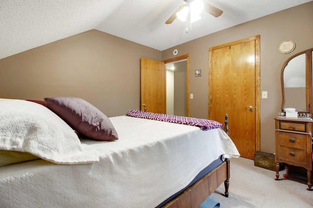 carpeted bedroom featuring ceiling fan, a closet, and vaulted ceiling