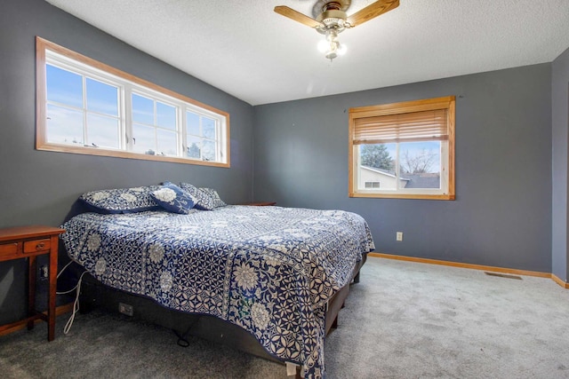 bedroom featuring carpet flooring, a textured ceiling, and ceiling fan