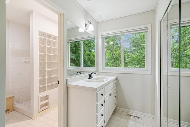 bathroom featuring a tile shower and vanity