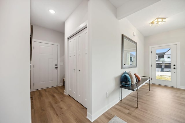 corridor featuring light hardwood / wood-style flooring and beam ceiling