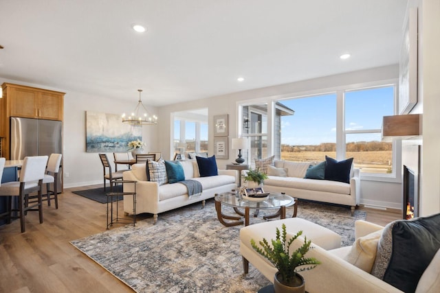 living room with light hardwood / wood-style flooring and an inviting chandelier