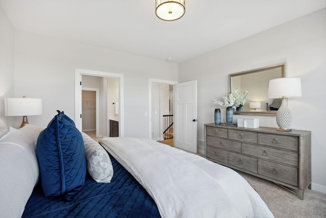 bedroom with light colored carpet and ensuite bath