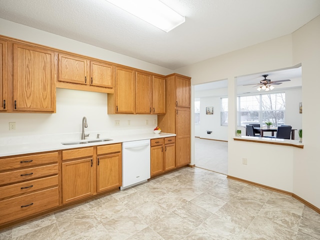 kitchen featuring a textured ceiling, white dishwasher, ceiling fan, and sink