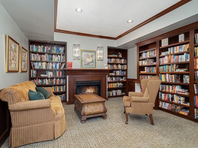 sitting room with carpet, a textured ceiling, and crown molding