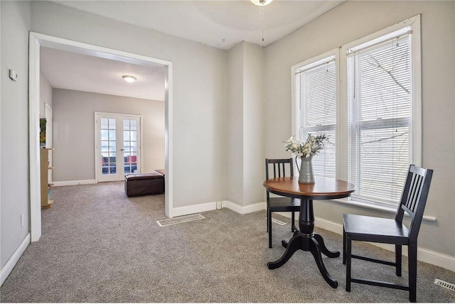 carpeted dining room featuring french doors