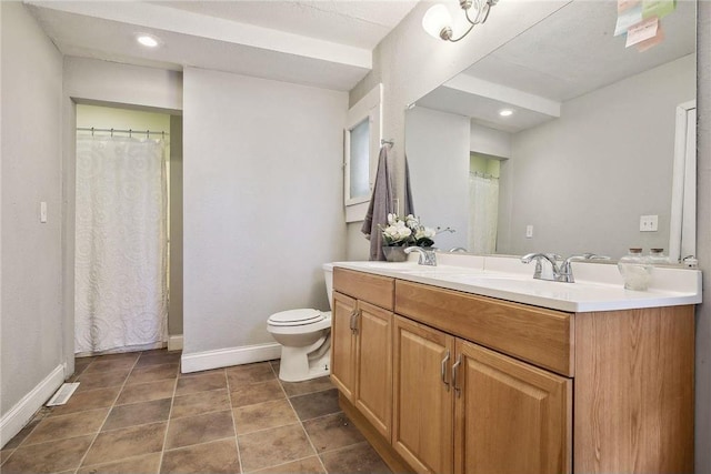 bathroom with toilet, vanity, and tile patterned floors