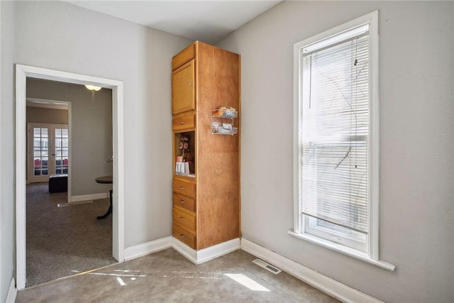 interior space with light carpet and french doors