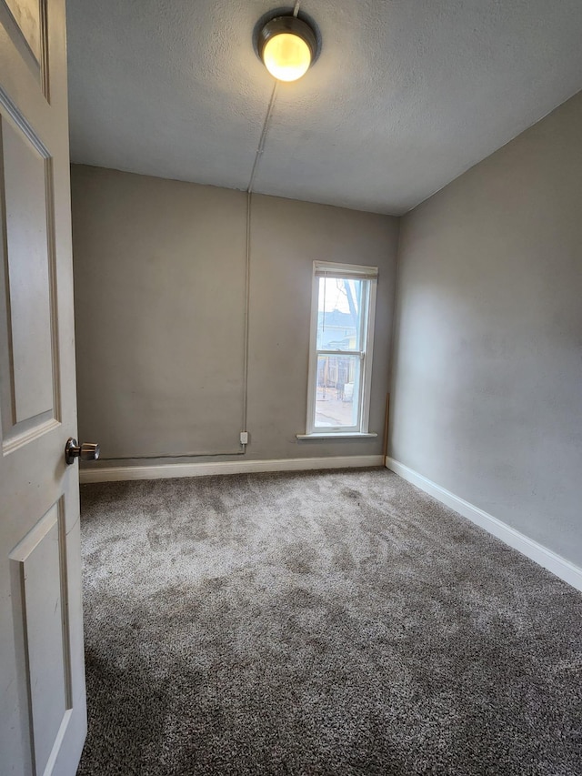 carpeted empty room featuring a textured ceiling